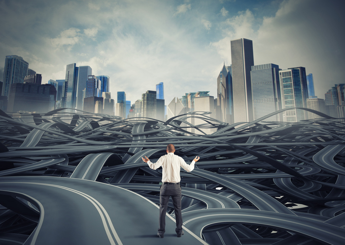 confused-businessman-standing-on-twisting-roads